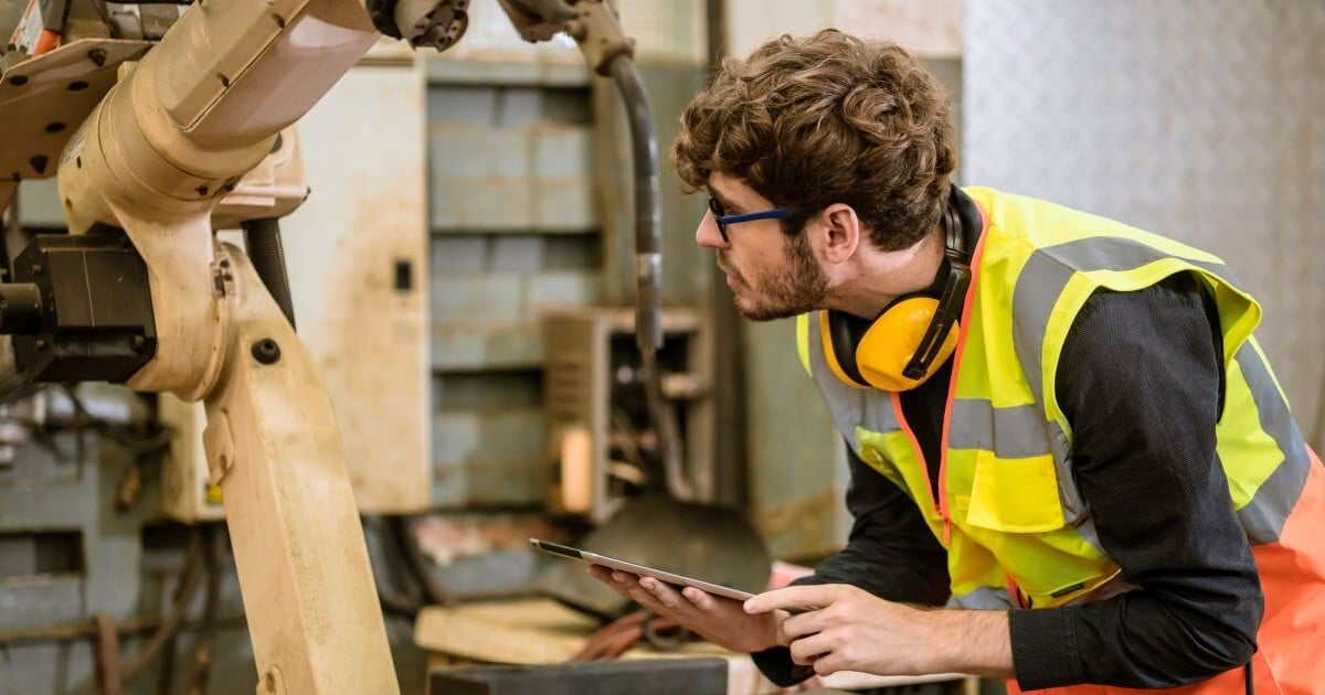 Equipment appraiser inspecting industrial machinery during an on-site appraisal
