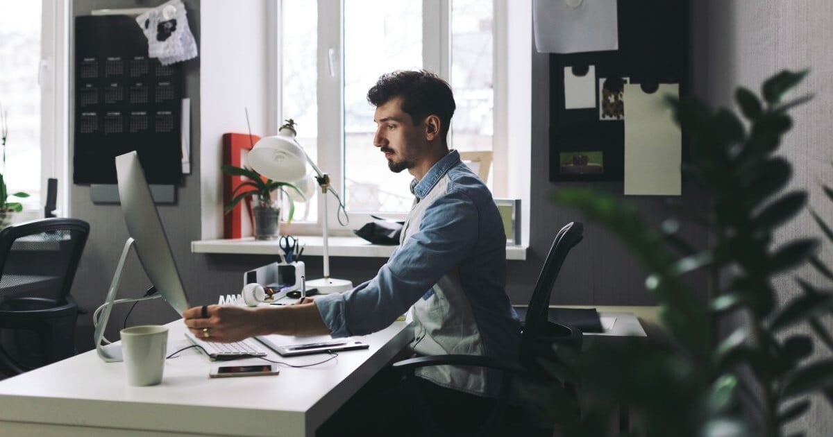 Equipment appraiser completing a desktop equipment appraisal from an office.
