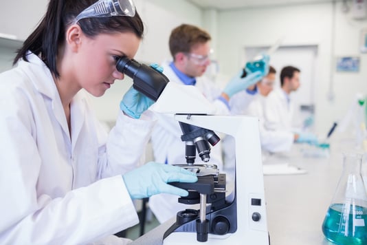 Side view of busy group of researchers working on experiments in the laboratory